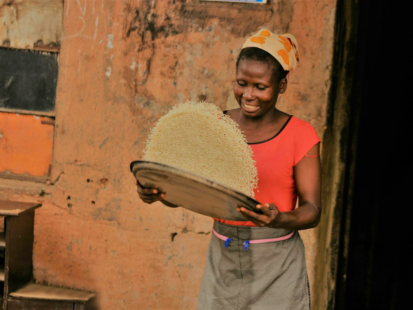 Woman winnowing rice with a basket